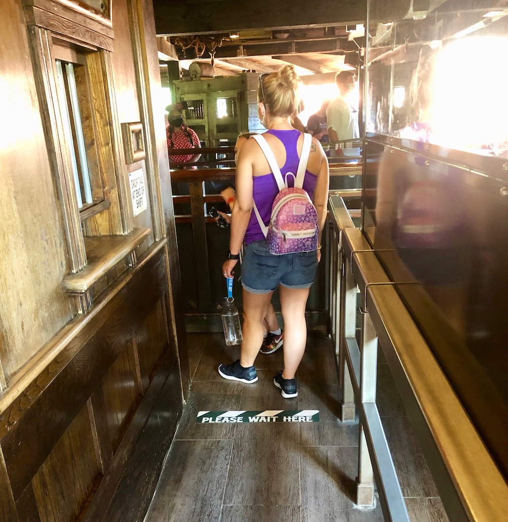 Floor markers and plexiglass keep guests distanced in the Big Thunder Mountain line queue.