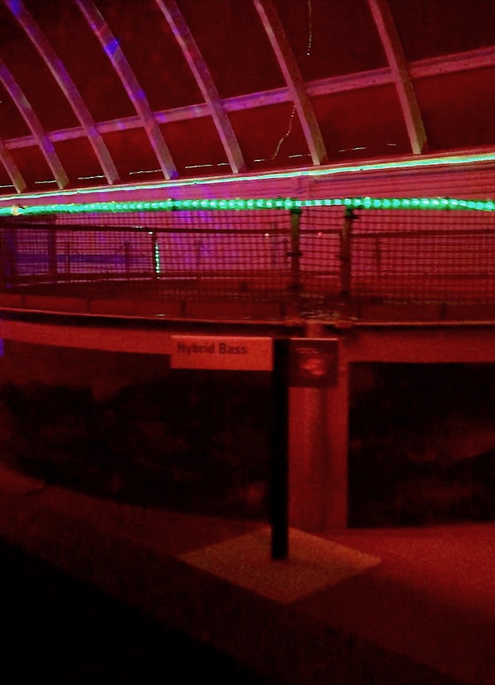 Red and green lights glow throughout the hydroponics lab within the Living with the Land attraction's holiday overlay. 